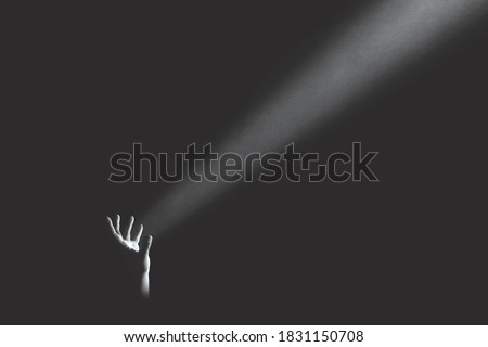 hand holding light rays in the darkness, hope concept