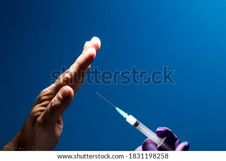 Denial of medical vaccination concept. Stop the medical injection. Refuse the vaccine medication. Protest against vaccination, man's hand rejecting preventive medicine