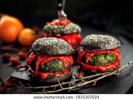 Halloween black burgers with vegetable cutlets, grilled red pepper and ketchup. Halloween food idea for  party