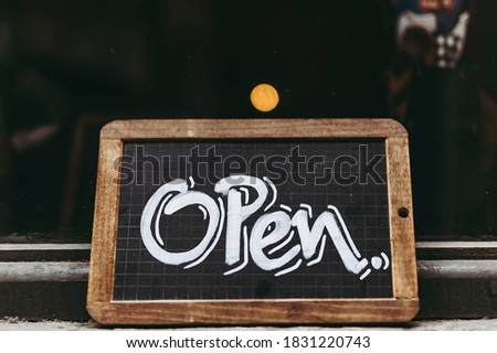 Chalkboard with white text Open on a shop door