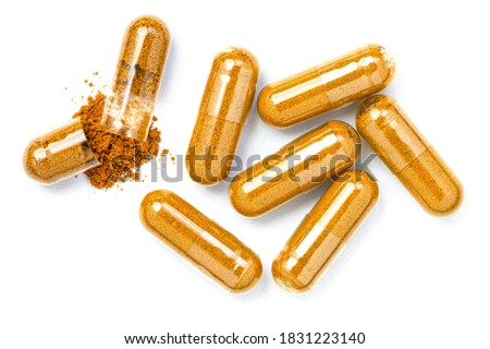 Closeup turmeric herbal powder capsules isolated on white background. Top view. Flat lay. Royalty-Free Stock Photo #1831223140