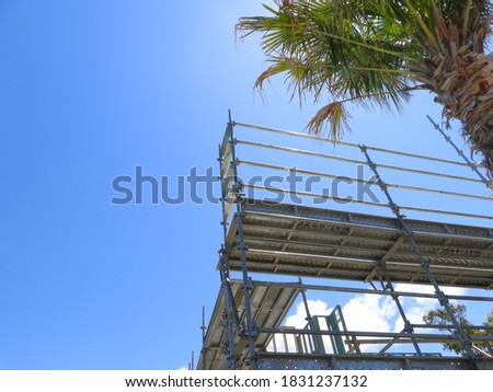 Scaffold a for New House and Land Costruction - Hi Set, 2 Level  - with Palm tree and Blue Sky background.