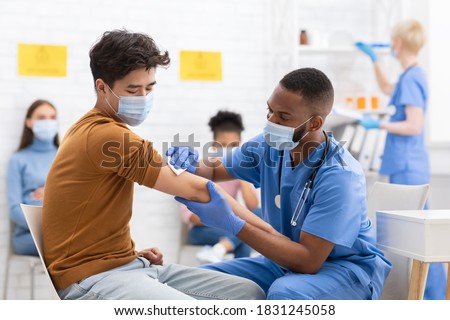 Covid-19 Vaccination. Asian Male Patient Getting Vaccinated Against Coronavirus Receiving Covid Vaccine Intramuscular Injection During Doctor's Appointment In Hospital. Corona Virus Immunization Royalty-Free Stock Photo #1831245058