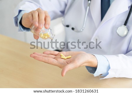 young doctor holding medication capsule in the palm. healthcare and medical concept