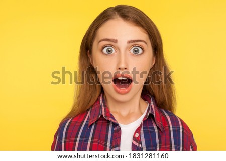 Wow, unbelievable! closeup caricature comic portrait of shocked or surprised funny young woman looking at camera with open mouth and amazed big eyes. indoor studio shot isolated on yellow background