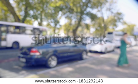 blurred background. city road with moving cars and pedestrians on a summer day.