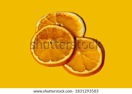 Citrus aroma spice. Dry orange slices. Christmas natural decor. New Year symbol. Round cut fruit composition isolated on yellow copy space background.