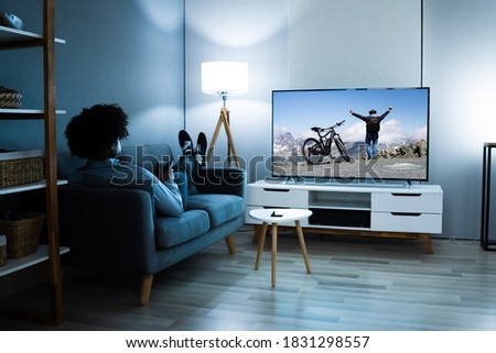 African American Streaming And Watching Movie On TV Screen Royalty-Free Stock Photo #1831298557