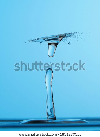 Water drop falling down. Abstract blue background.