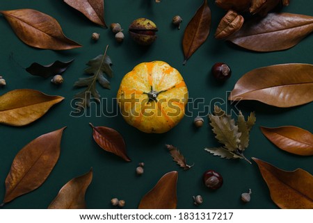 Autumn composition made of pumpkins, dried leaves, chestnuts and acorns. Autumn, fall, halloween concept. Flat lay, top view.