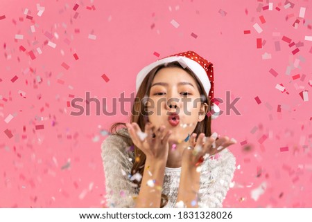 Portrait of two lovely cute asian women in christmas hats  looking at camera isolated over pink background.young asian woman smile in christmas, new year, valentine day, birthday celebration concept.