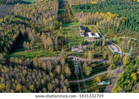 Aerial view of power distribution network with fall colors and forest and paths