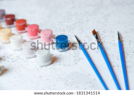 Paints and brushes. Painting by numbers.