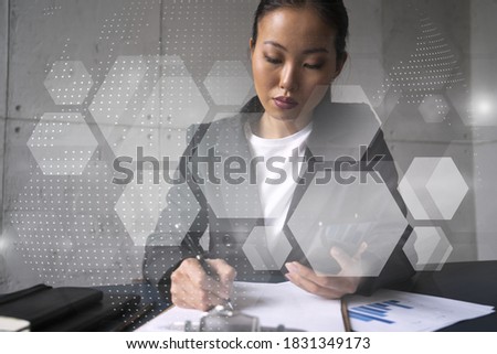 Businesswoman taking notes and abstract tech icons hologram. Double exposure. Technology security network solution concept.