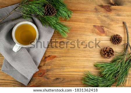 Pine needles tea in white cup top view with copy space. Healthy winter beverage in camping, pine tree needles tea in mug. Medicine scurvy, source of vitamin C and carotene Royalty-Free Stock Photo #1831362418