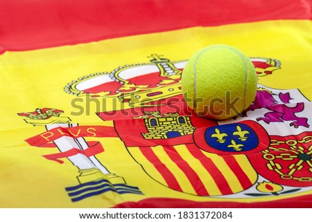 TENNIS BALL ON THE SPANISH FLAG SHIELD. SPANISH TENNIS AND PADEL SUCCESS. BETS IN SPORTS. Royalty-Free Stock Photo #1831372084
