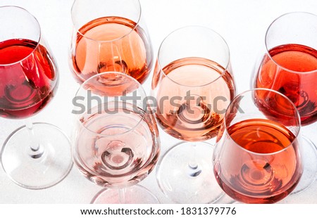 Rose wine glasses set on wine tasting. Degustation different varieties, colors and shades of pink wine concept. White background, top view Royalty-Free Stock Photo #1831379776