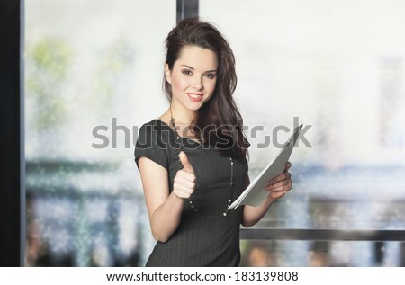 Successful businesswomen in the office showing thumb up 