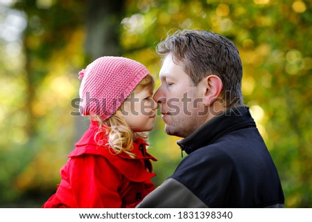 Happy young father having fun cute toddler daughter, family portrait together. Man with beautiful baby girl in autumn forest or park. Dad with little child outdoors, hugging. Love, bonding.