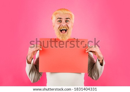 Portrait of handsome man posing and holding empty red billboard or blank board