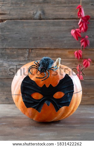 Pumpkin in black glasses on a wooden background for the holiday of halloween. Vertical photo.