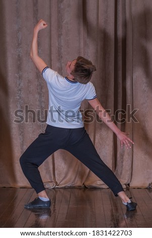 A young boy dancer rehearsing on stage, the elements of dance. The emotions in the choreography