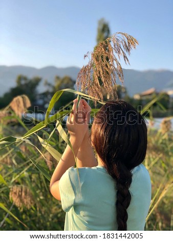 woman with braids sniffing Pampas herb(Cortaderia Selloana)