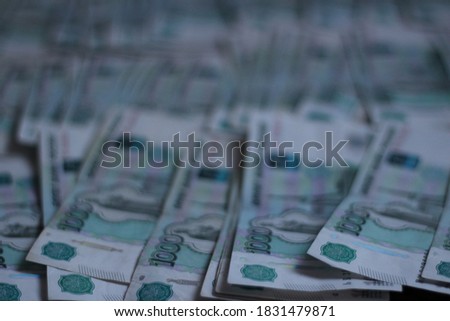 Image of the Russian currency. Photo of one thousand rubles banknotes. Money is spread over the entire surface of the table and covers a large area. High quality photo