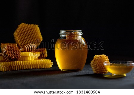 Honey with honeycomb on black table, top view. space for text. Royalty-Free Stock Photo #1831480504