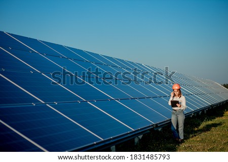 Inspector Engineer Woman Holding Digital Tablet Working in Solar Panels Power Farm, Photovoltaic Cell Park, Green Energy Concept. Royalty-Free Stock Photo #1831485793