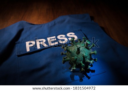 Creative concept of manipulation with media or fake news. The Covid19 miniature on journalist vest. Selective focus