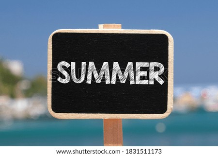 SUMMER. The word summer written on a chalkboard.