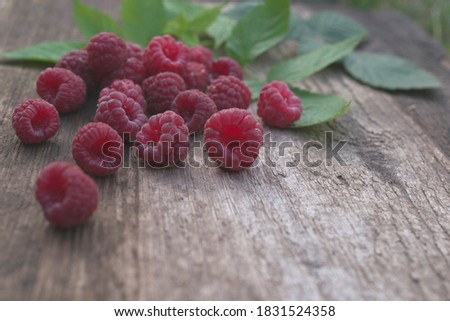 
Ripe raspberries on a wooden table.