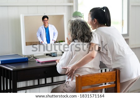 Senior Asian woman and adult daughter making video call with her doctor at home. online medical consultation concept.