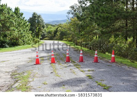 Road cone / orange traffic cones standing in a row on asphalt on the road mountain