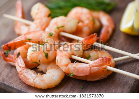 Salad grilled shrimp skewers delicious seasoning spices on wooden plate appetizing cooked shrimps baked prawns , Seafood shelfish with rosemary and lemon