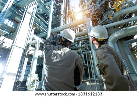 Industrial engineer or worker checking pipeline at oil and gas refinery plant form industry zone with sunrise and cloudy sky, oil and gas Industry concept. Royalty-Free Stock Photo #1831612183