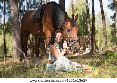 Young beautiful woman walking in the forest with her horse	