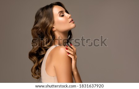Beautiful woman in profile  with long  and   shiny wavy  hair .  Beauty  model girl with curly hairstyle .