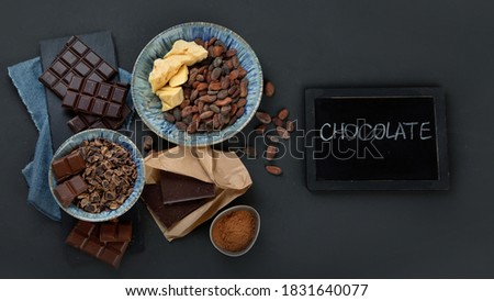 Delicious chocolate bars and pieces. Top view, copy space, chalkboard