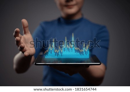 Woman using tablet planning digital marketing with chart hologram effect.