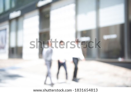 Abstract blurred of business people walking on sidewalk in the business area in the city and modern style office buildings background, urban scene