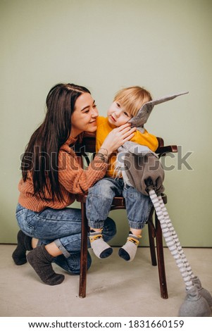 Mother with her little son sitting in chair