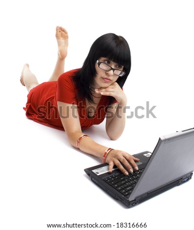 Beautiful girl in red clothing; with computer isolated on white. Girl lie on the floor. See more pictures is my portfolio.