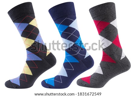 three volumetric socks with a pattern of colored rhombuses, on a white background, concept, isolate