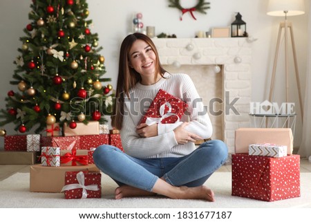 beautiful young woman in a Christmas interior with gifts. Place for text, festive background