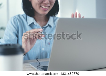 Smiling asian business woman video calling with client online working via laptop computer in office. Businesswoman making facetime video conference, using zoom online meeting app via laptop Royalty-Free Stock Photo #1831682770