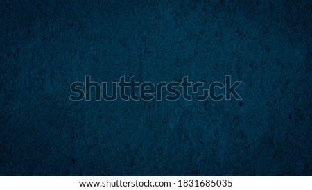 Beautiful Abstract Grunge Decorative Navy Blue Dark Stucco Wall Background. Image of the dark colored concrete wall has light from the center of the picture. There is space for designing and text.