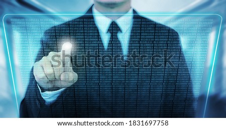 The hand of a businessman or a robot is poking at a transparent screen containing binary code, a futuristic concept.