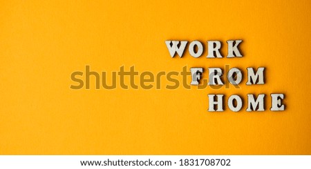 Wooden letters text WORK FROM HOME in front yellow background, copy space, banner for freelance coronavirus quarantine isolation
